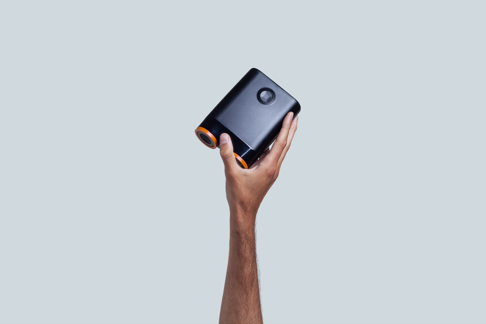 Droid compact vacuum device held in one hand at an angled view
